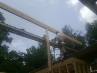 Carpenter setting a ridge beam over a new addition frame — Ice Dam Removal by Roofing Brothers in Amesbury