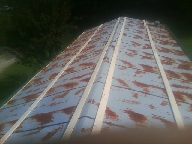 Rusted metal roof panels with new wood purlins before replacement — Storm Damage Roof Repair in Amesbury by Roofing Brothers