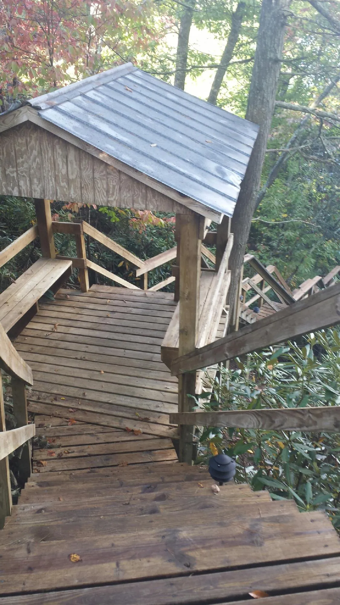 Metal roofed shelter over wooden steps on a wooded walkway — Skylight Repair & Installation work by our crew in Amesbury