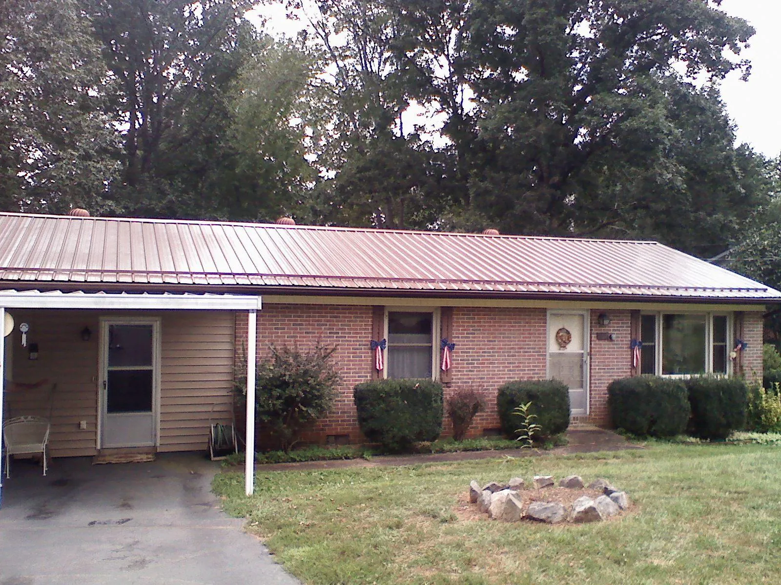 Bronze metal roof and carport on a brick ranch home — Roof Repair work by our crew in Amesbury