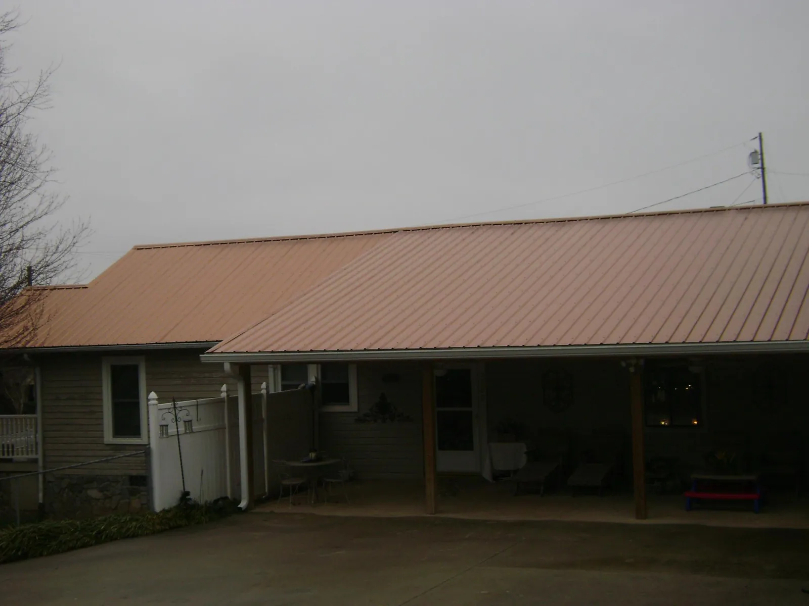 Copper toned metal roof over a wide covered patio in Amesbury